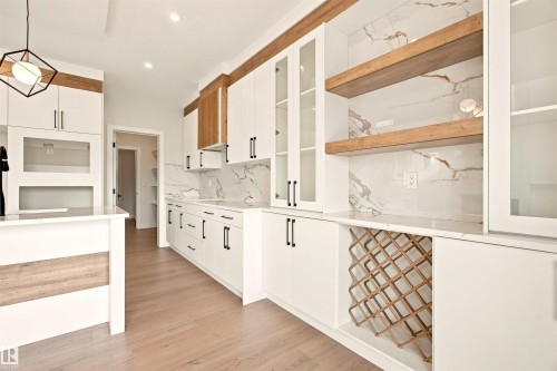White cabinetry with matte black hardware, wood-finish accents, and a built-in wine rack - 10462 104 Street, Morinville, AB 