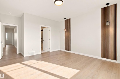 Light wood-finish flooring with white walls and trim - 10462 104 Street, Morinville, AB 