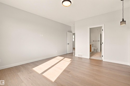 Light wood-finish flooring with a neutral wall color - 10462 104 Street, Morinville, AB 