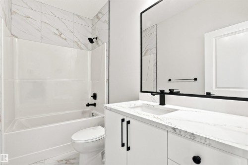 Modern vanity with integrated sink, white cabinetry, and matte black fixtures - 10462 104 Street, Morinville, AB 