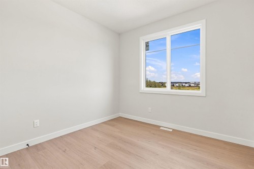 Light-toned wood-finish flooring, white trim, and a white-framed window - 10462 104 Street, Morinville, AB 