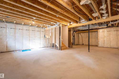 Unfinished basement with exposed wooden joists, insulated walls, concrete flooring, and partial wooden framing - 10462 104 Street, Morinville, AB 