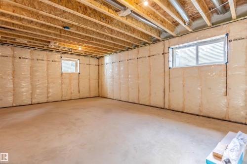 Unfinished space featuring two windows and exposed ceiling joists - 10462 104 Street, Morinville, AB 