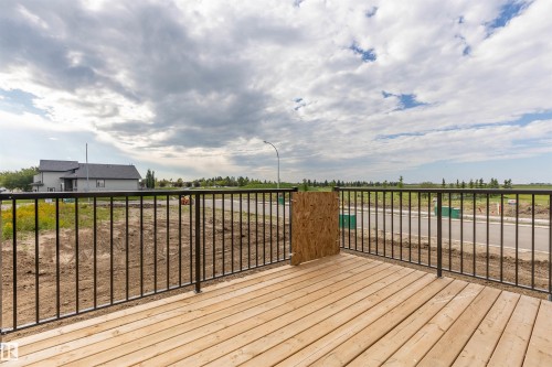 Expansive outdoor deck featuring wood planking and black metal railing - 10462 104 Street, Morinville, AB 