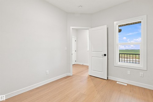 Light-toned wood-finish flooring complements white walls - 10462 104 Street, Morinville, AB 