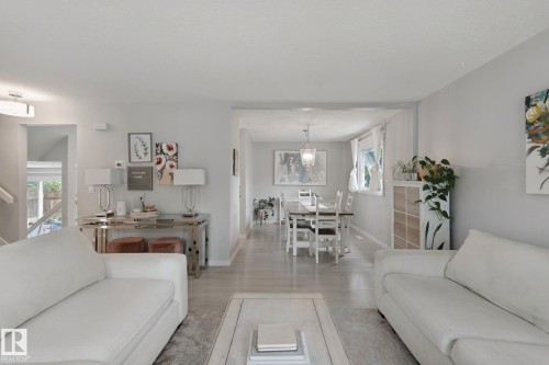 Light-toned flooring, neutral wall colors, recessed lighting, and a dining area with a chandelier - 5 Labelle Crescent, St. Albert, AB 