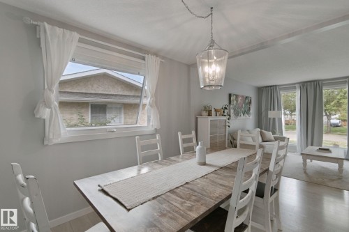 Open-concept living area with light-colored flooring and a decorative chandelier - 5 Labelle Crescent, St. Albert, AB 