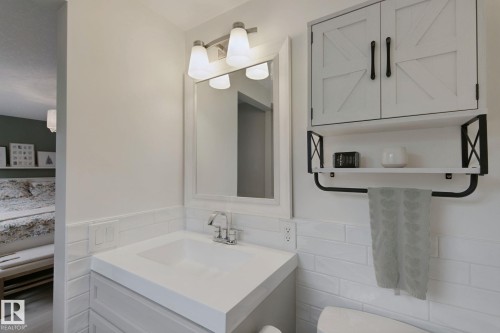 Modern vanity with integrated sink, chrome faucet, and white subway tile backsplash - 5 Labelle Crescent, St. Albert, AB 