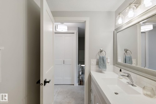 Vanity with integrated rectangular sink, light-toned countertop, and subway tile backsplash - 5 Labelle Crescent, St. Albert, AB 