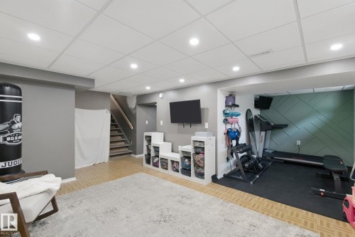 Finished basement with recessed lighting, wood-finish flooring, and a dedicated exercise area with specialized flooring - 5 Labelle Crescent, St. Albert, AB 