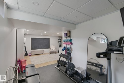 Recessed lighting illuminates the space, featuring a large chalkboard wall, smooth white walls, and a drop ceiling - 5 Labelle Crescent, St. Albert, AB 