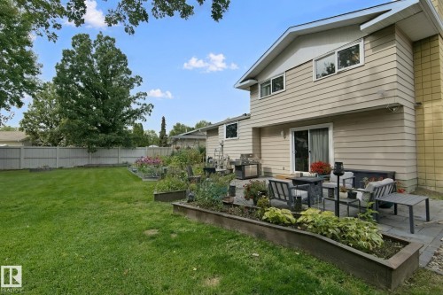 Expansive lawn, patio area, raised garden beds, sliding glass door, and exterior siding - 5 Labelle Crescent, St. Albert, AB 