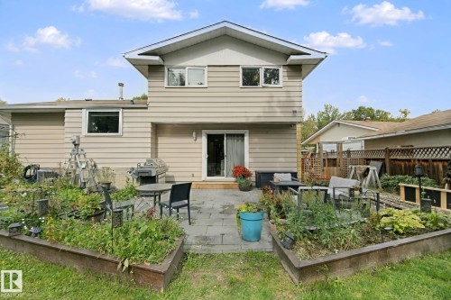 Rear exterior with siding, featuring a patio, sliding glass door, and raised garden beds - 5 Labelle Crescent, St. Albert, AB 