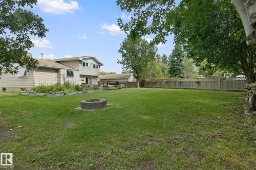 Expansive backyard with a manicured lawn, a built-in fire pit, and raised garden beds - 5 Labelle Crescent, St. Albert, AB 