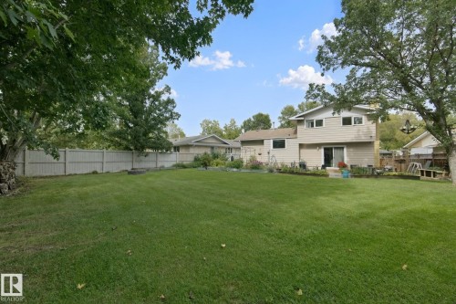 Expansive green lawn with mature trees and a privacy fence - 5 Labelle Crescent, St. Albert, AB 