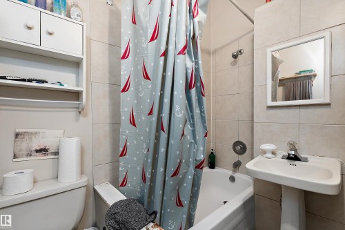 Pedestal sink with chrome faucet, white framed mirror, and built-in wall cabinet with shelving - 10816 92 Street Nw, Edmonton, AB 