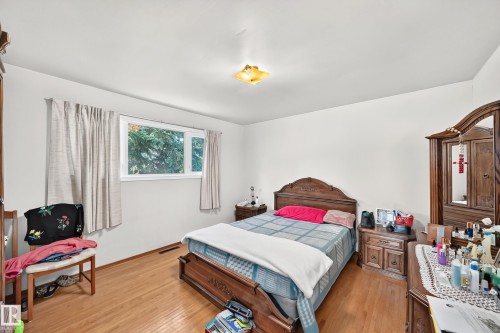 Bright interior room featuring wood-finish flooring, white walls, and a ceiling light fixture - 15703 84 Avenue Nw, Edmonton, AB - Indoor Photo Showing Bedroom