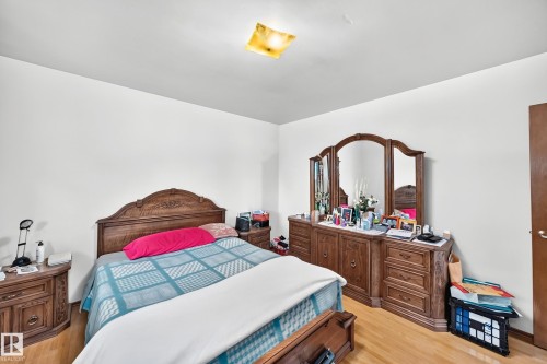 Hardwood-finish flooring complements white walls - 15703 84 Avenue Nw, Edmonton, AB - Indoor Photo Showing Bedroom