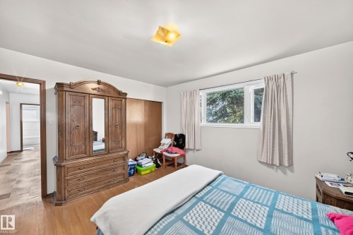 Bright interior space featuring wood-finish flooring, a white-framed window, and a light-colored ceiling - 15703 84 Avenue Nw, Edmonton, AB - Indoor Photo Showing Bedroom