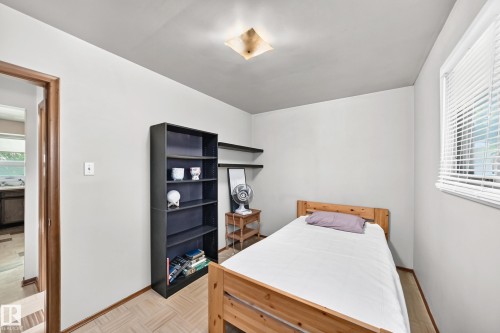 Light-colored walls and wood-finish flooring define this room, featuring a window with horizontal blinds - 15703 84 Avenue Nw, Edmonton, AB - Indoor