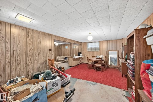 Finished lower level featuring wood paneling, drop ceiling, and a distinct red carpeted area - 15703 84 Avenue Nw, Edmonton, AB - Indoor