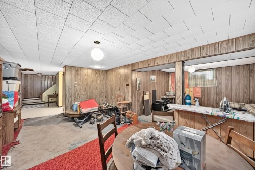 Finished lower level with wood paneling, drop ceiling, and a prominent staircase - 15703 84 Avenue Nw, Edmonton, AB - Indoor
