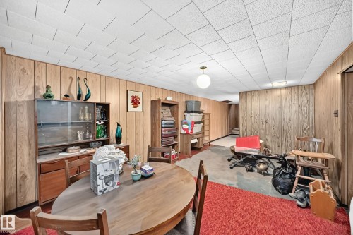 Room featuring wood-paneled walls and a drop ceiling - 15703 84 Avenue Nw, Edmonton, AB - Indoor