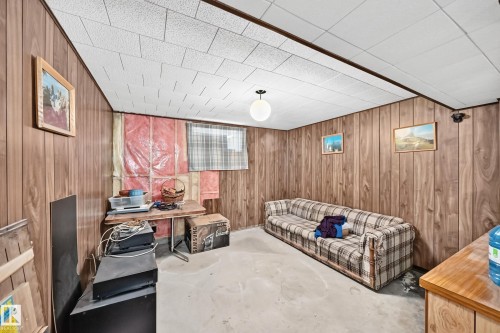 Basement space featuring wood paneling, a drop ceiling, and exposed insulation - 15703 84 Avenue Nw, Edmonton, AB - Indoor