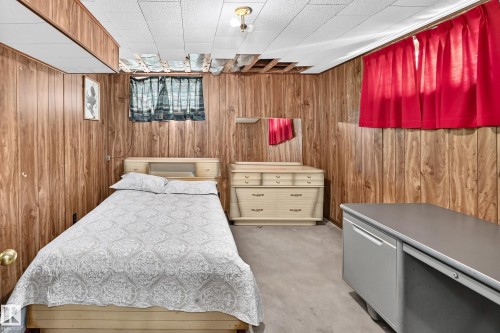 Wood-paneled room featuring a drop ceiling with some exposed joists - 15703 84 Avenue Nw, Edmonton, AB - Indoor