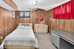 Wood-paneled room featuring a drop ceiling with some exposed joists - 