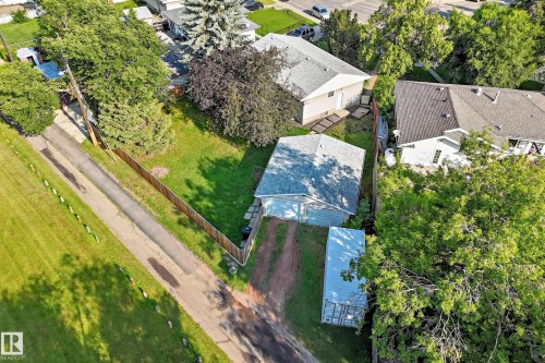 Aerial perspective showcasing the property with a detached garage, a gravel driveway, and a wooden perimeter fence - 15703 84 Avenue Nw, Edmonton, AB - Outdoor With View