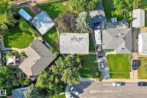 Aerial view showcasing a residential property with a shingled roof, a green lawn, and a paved driveway - 15703 84 Avenue Nw, Edmonton, AB - Outdoor With View