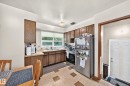 Kitchen featuring wood-finish cabinetry, a double basin sink, and a stainless steel refrigerator - 15703 84 Avenue Nw, Edmonton, AB  - Indoor Photo Showing Kitchen With Double Sink 