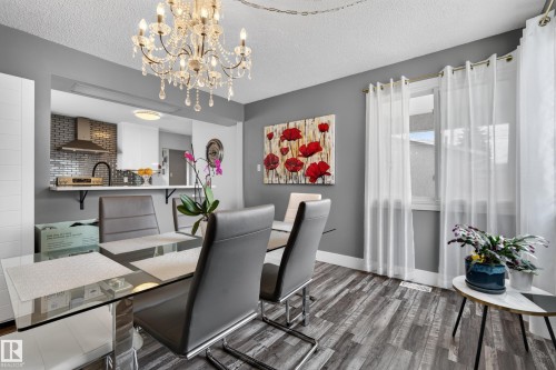 Wood-finish flooring, a crystal chandelier, and a pass-through window with a breakfast bar - 13512 111 Street Nw, Edmonton, AB 