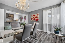 Wood-finish flooring, a crystal chandelier, and a pass-through window with a breakfast bar - 