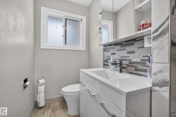 White vanity with an integrated rectangular sink, sleek cabinetry, and a contemporary tile backsplash - 