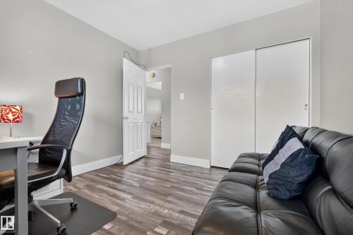 Wood-finish flooring, white sliding closet doors, and a white panel door - 13512 111 Street Nw, Edmonton, AB 