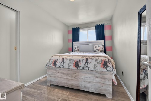 Sliding closet door with gold-tone hardware, wood-finish flooring, and a large window - 13512 111 Street Nw, Edmonton, AB 