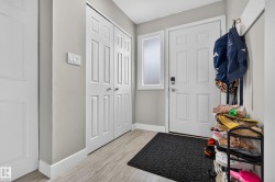 Entryway featuring light wood-finish flooring, a paneled door with frosted sidelite, and bi-fold closet doors - 
