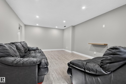 Recessed lighting, light gray wall paint, wood-finish flooring, and a floating wall shelf - 13512 111 Street Nw, Edmonton, AB 