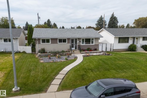 Front exterior with light grey siding and a partial stone facade - 13512 111 Street Nw, Edmonton, AB 