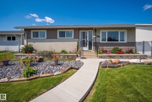 Single-story residence featuring a concrete walkway, established landscaping with rock features, and a stone-clad retaining wall - 13512 111 Street Nw, Edmonton, AB 