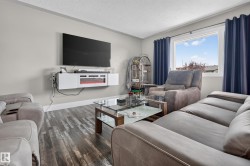 Wood-finish flooring with a wall-mounted media console featuring an integrated electric fireplace - 