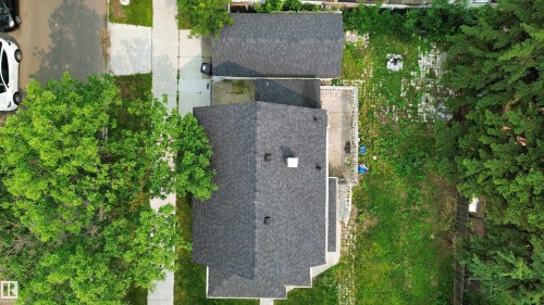Aerial perspective showcasing a property with a dark shingle roof, a detached garage, and a concrete patio - 9124 119 Avenue Nw, Edmonton, AB - Outdoor
