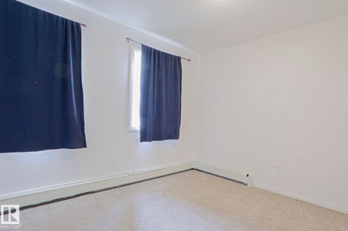 Neutral wall color, carpeted flooring, and two windows - #108 1204 156 St Nw, Edmonton, AB 