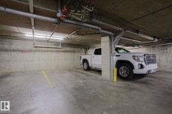 Underground parking space featuring a concrete floor, concrete walls, and overhead lighting - 
