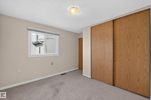 Neutral wall color, carpet flooring, window with blinds, wood-finish sliding doors, and ceiling-mounted light fixture - 17749 95 Street Nw, Edmonton, AB 