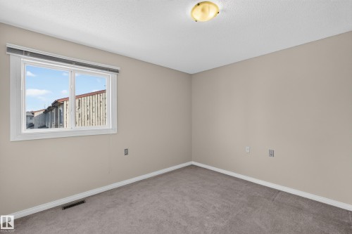 Neutral wall paint, textured ceiling, flush mount light fixture, carpet flooring, and a single window - 17749 95 Street Nw, Edmonton, AB 