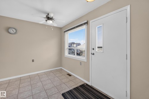 Tile flooring, neutral wall paint, white trim, ceiling fan, and a window with a roller blind - 17749 95 Street Nw, Edmonton, AB 