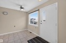 Tile flooring, neutral wall paint, white trim, ceiling fan, and a window with a roller blind - 17749 95 Street Nw, Edmonton, AB 